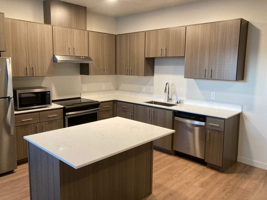 An apartment kitchen with white quartz countertops